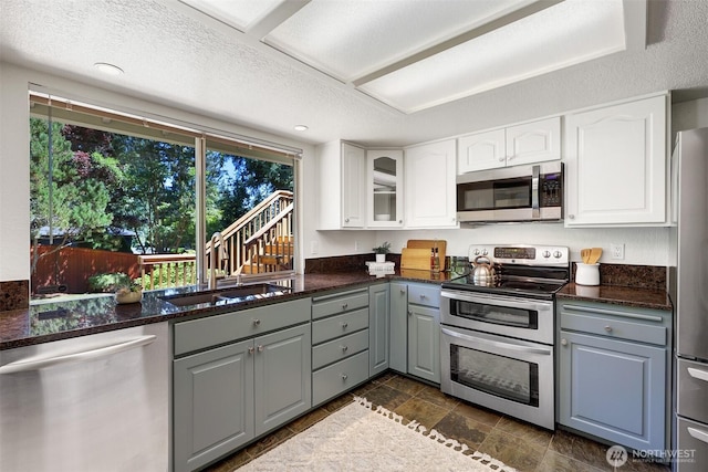 207 215th St SE, Bothell, WA 98021 - kitchen with appliances with stainless steel finishes, gray cabinets, white cabinetry, glass insert cabinets, and a textured ceiling