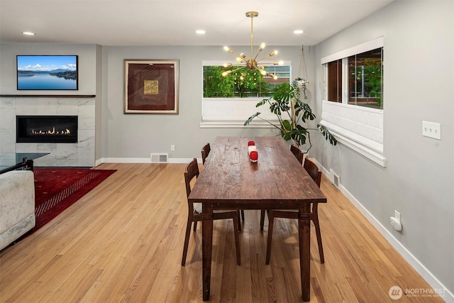 7503 32nd Ave NE, Seattle, WA 98115 - dining space featuring a chandelier, light wood-type flooring, a fireplace, and recessed lighting