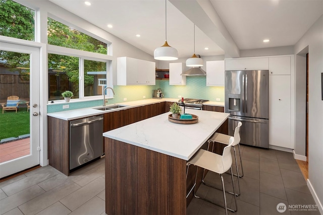 7503 32nd Ave NE, Seattle, WA 98115 - kitchen with appliances with stainless steel finishes, white cabinetry, tile patterned floors, a kitchen island, and a breakfast bar area