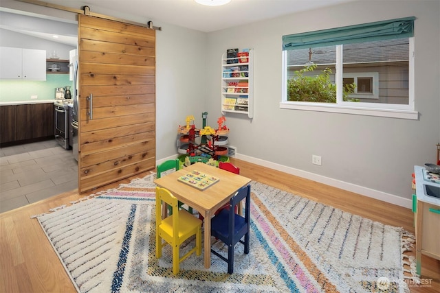 7503 32nd Ave NE, Seattle, WA 98115 - rec room with light wood-style flooring and a barn door
