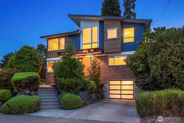 7503 32nd Ave NE, Seattle, WA 98115 - contemporary home with driveway, an attached garage, stairway, and brick siding