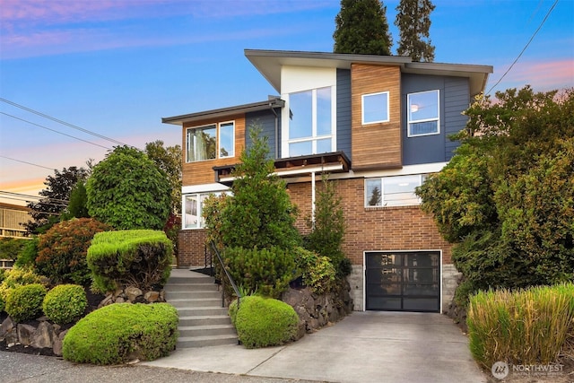 7503 32nd Ave NE, Seattle, WA 98115 - contemporary house featuring a garage, concrete driveway, and brick siding