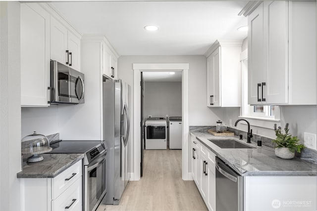 1316 115th St S, Tacoma, WA 98444 - kitchen featuring appliances with stainless steel finishes, washer and clothes dryer, light wood finished floors, white cabinets, and recessed lighting