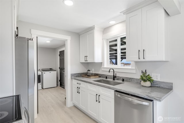 1316 115th St S, Tacoma, WA 98444 - kitchen featuring stainless steel appliances, independent washer and dryer, light wood-style floors, white cabinets, and recessed lighting