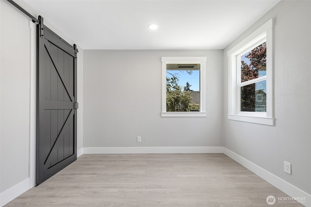 1316 115th St S, Tacoma, WA 98444 - unfurnished bedroom with a barn door, light wood-type flooring, and recessed lighting
