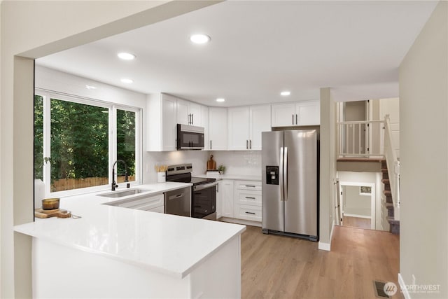 31228 47th Pl SW, Federal Way, WA 98023 - kitchen featuring appliances with stainless steel finishes, light wood finished floors, light countertops, white cabinets, and recessed lighting