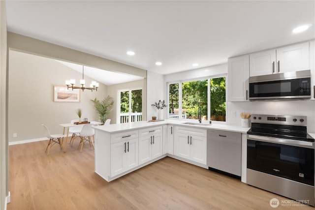 31228 47th Pl SW, Federal Way, WA 98023 - kitchen featuring appliances with stainless steel finishes, a chandelier, plenty of natural light, a peninsula, and recessed lighting