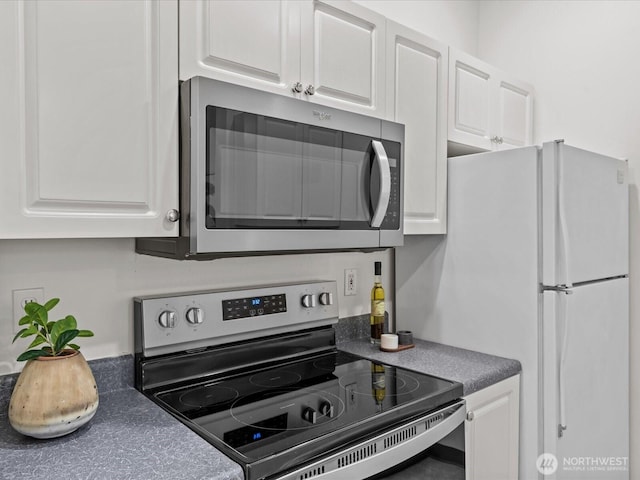 2415 2nd Ave Unit 541, Seattle, WA 98121 - kitchen featuring stainless steel appliances, white cabinetry, and dark countertops