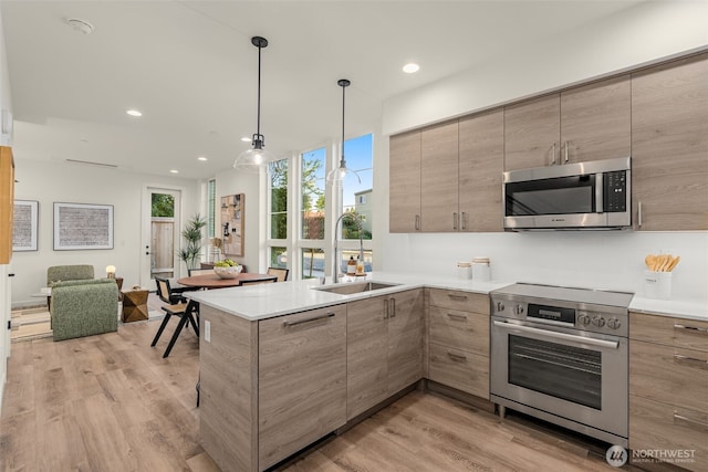 112C 2nd St S, Kirkland, WA 98033 - kitchen with stainless steel appliances, light wood finished floors, a peninsula, open floor plan, and recessed lighting