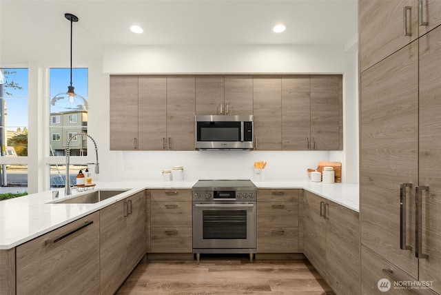 112C 2nd St S, Kirkland, WA 98033 - kitchen with appliances with stainless steel finishes, light wood-style floors, modern cabinets, pendant lighting, and a peninsula