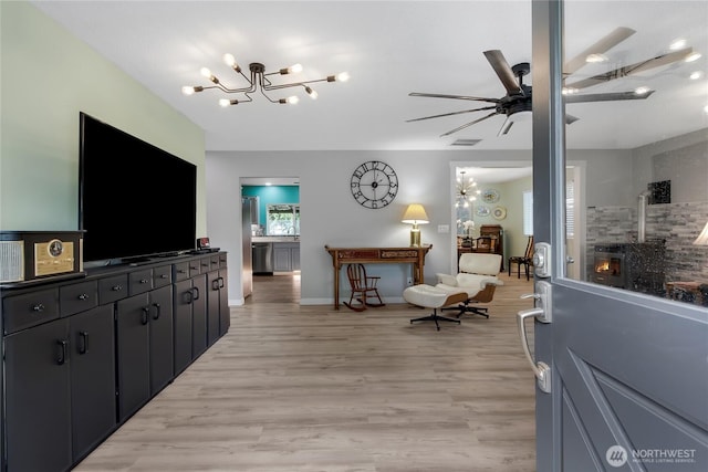 6808 243rd Ave E, Buckley, WA 98321 - living room with a chandelier, ceiling fan, and light wood-type flooring