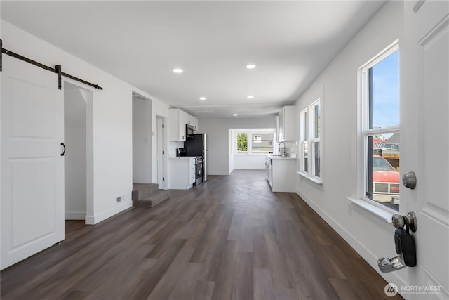 1433 E 32nd St, Tacoma, WA 98404 - unfurnished living room with a barn door, recessed lighting, and dark wood-style flooring