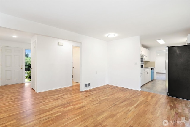 16548 115th Ave SE, Renton, WA 98055 - unfurnished living room with light wood-style floors and baseboards