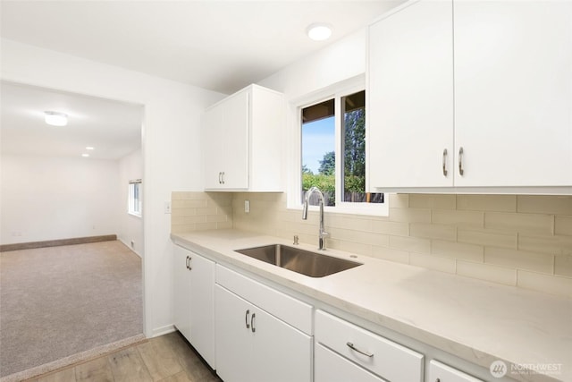16548 115th Ave SE, Renton, WA 98055 - kitchen with light countertops, backsplash, light wood finished floors, and white cabinetry