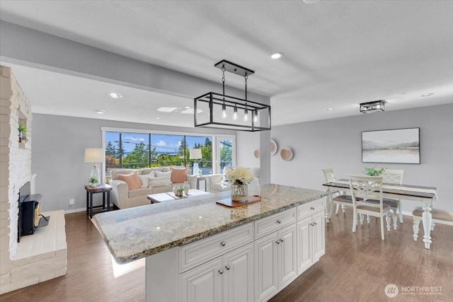 619 8th Ave S, Edmonds, WA 98020 - kitchen with wood finished floors, white cabinets, light stone countertops, a center island, and recessed lighting