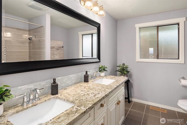 619 8th Ave S, Edmonds, WA 98020 - bathroom featuring decorative backsplash, double vanity, a tile shower, and tile patterned flooring