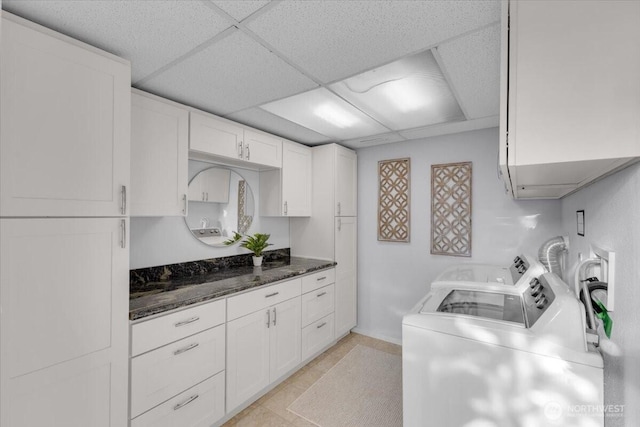 619 8th Ave S, Edmonds, WA 98020 - kitchen with washer and dryer, a drop ceiling, white cabinets, and dark stone countertops