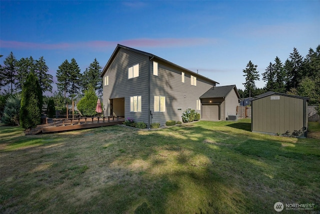 4749 NE Waxwing Ct, Lacey, WA 98516 - back of property at dusk featuring a shed, a deck, a yard, and an attached garage