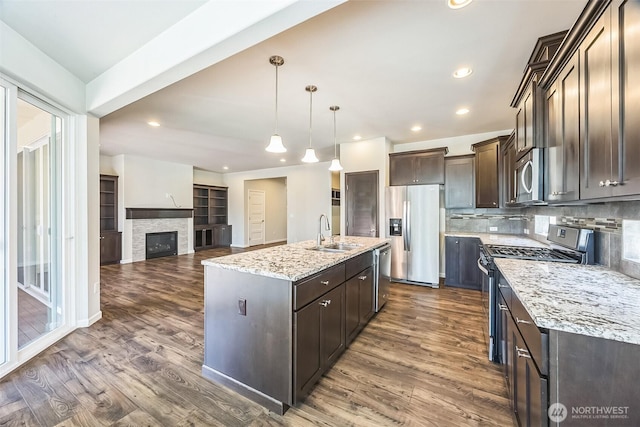 4749 NE Waxwing Ct, Lacey, WA 98516 - kitchen with stainless steel appliances, dark wood-type flooring, dark brown cabinetry, light stone countertops, and recessed lighting