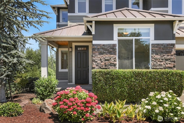 6821 9th St E, Fife, WA 98424 - view of exterior entry with a standing seam roof, stone siding, a metal roof, and stucco siding