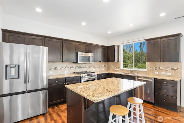6821 9th St E, Fife, WA 98424 - kitchen with stainless steel appliances, dark brown cabinetry, dark wood-style floors, a kitchen island, and recessed lighting