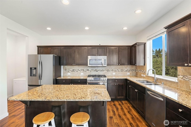 6821 9th St E, Fife, WA 98424 - kitchen with appliances with stainless steel finishes, dark wood-style flooring, a breakfast bar area, and recessed lighting