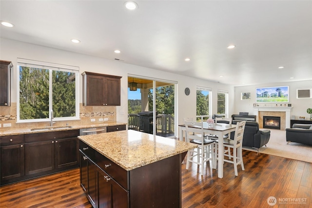 6821 9th St E, Fife, WA 98424 - kitchen with a glass covered fireplace, dark wood-style floors, recessed lighting, and decorative backsplash