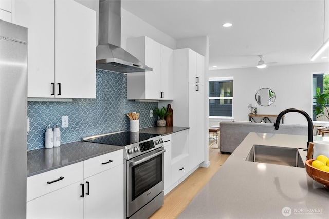 1327 N 185th St Unit A, Shoreline, WA 98133 - kitchen featuring wall chimney exhaust hood, stainless steel appliances, light wood-style flooring, recessed lighting, and decorative backsplash