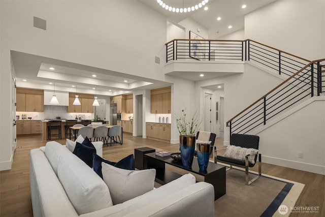15734 SE 25th St, Bellevue, WA 98008 - living room with light wood finished floors, recessed lighting, stairs, a raised ceiling, and a high ceiling