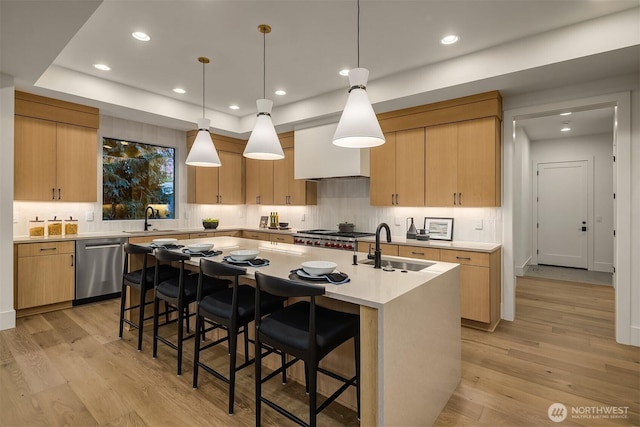 15734 SE 25th St, Bellevue, WA 98008 - kitchen featuring appliances with stainless steel finishes, a kitchen island with sink, light wood-type flooring, light countertops, and backsplash