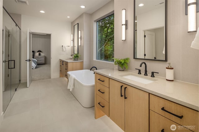 15734 SE 25th St, Bellevue, WA 98008 - bathroom with two vanities, a stall shower, a freestanding tub, recessed lighting, and tile patterned flooring