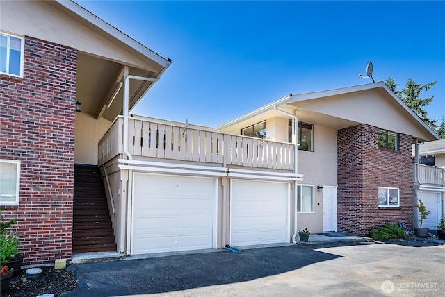 20632 76th Ave W Unit 4, Edmonds, WA 98026 - view of side of property featuring a balcony, brick siding, stucco siding, and driveway
