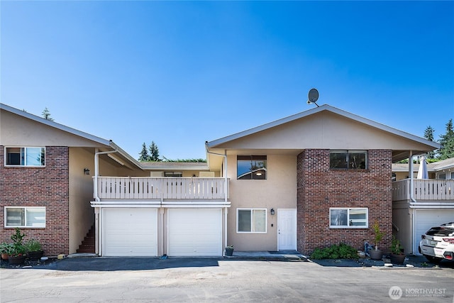 20632 76th Ave W Unit 4, Edmonds, WA 98026 - view of front of house featuring a balcony, stucco siding, driveway, and brick siding