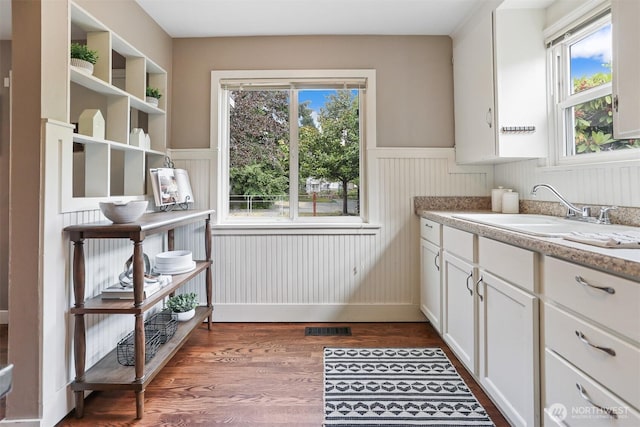 8153 34th Ave SW, Seattle, WA 98126 - kitchen featuring wainscoting, wood finished floors, white cabinets, light countertops, and open shelves