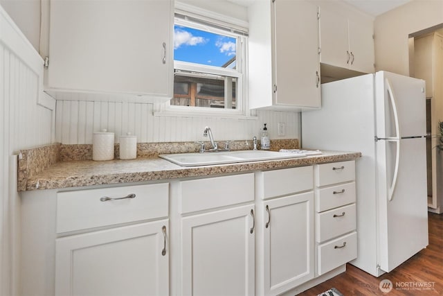 8153 34th Ave SW, Seattle, WA 98126 - kitchen with freestanding refrigerator, dark wood-style flooring, white cabinetry, and light countertops