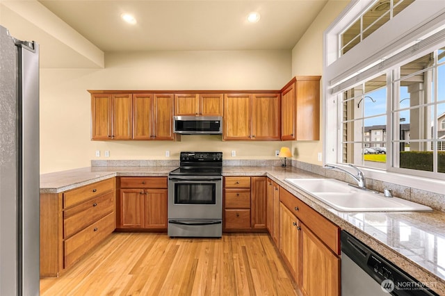1725 Harrison Pl Unit 104, Lynden, WA 98264 - kitchen with stainless steel appliances, light wood finished floors, brown cabinetry, tile counters, and recessed lighting