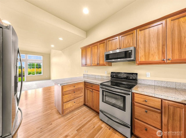 1725 Harrison Pl Unit 104, Lynden, WA 98264 - kitchen with stainless steel appliances, light wood-style flooring, a peninsula, tile counters, and brown cabinetry