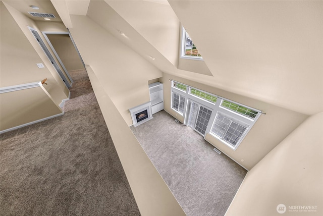 1725 Harrison Pl Unit 104, Lynden, WA 98264 - unfurnished living room featuring carpet, a fireplace with flush hearth, and a high ceiling