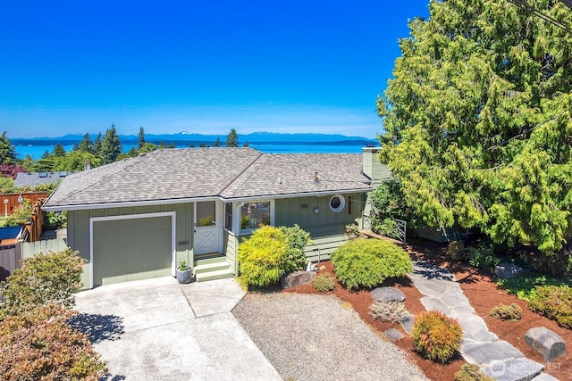 9423 45th Ave SW, Seattle, WA 98136 - view of front of property with a garage, concrete driveway, roof with shingles, and a water and mountain view