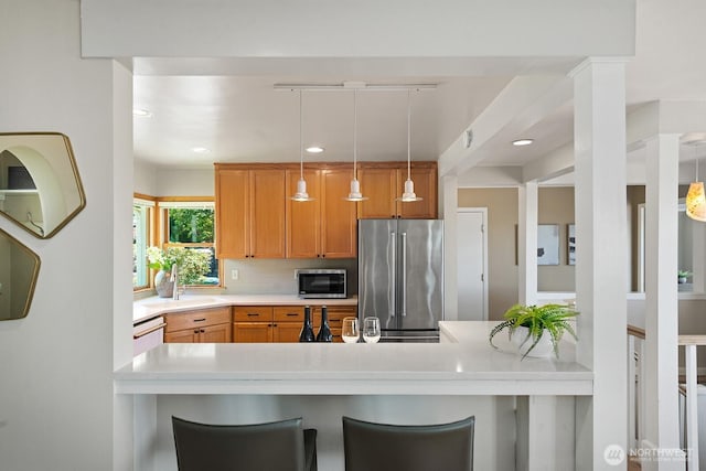 9423 45th Ave SW, Seattle, WA 98136 - kitchen featuring appliances with stainless steel finishes, light countertops, backsplash, pendant lighting, and a breakfast bar