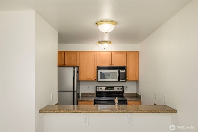 300 10th Ave Unit A310, Seattle, WA 98122 - kitchen featuring electric range oven, freestanding refrigerator, a peninsula, and brown cabinetry