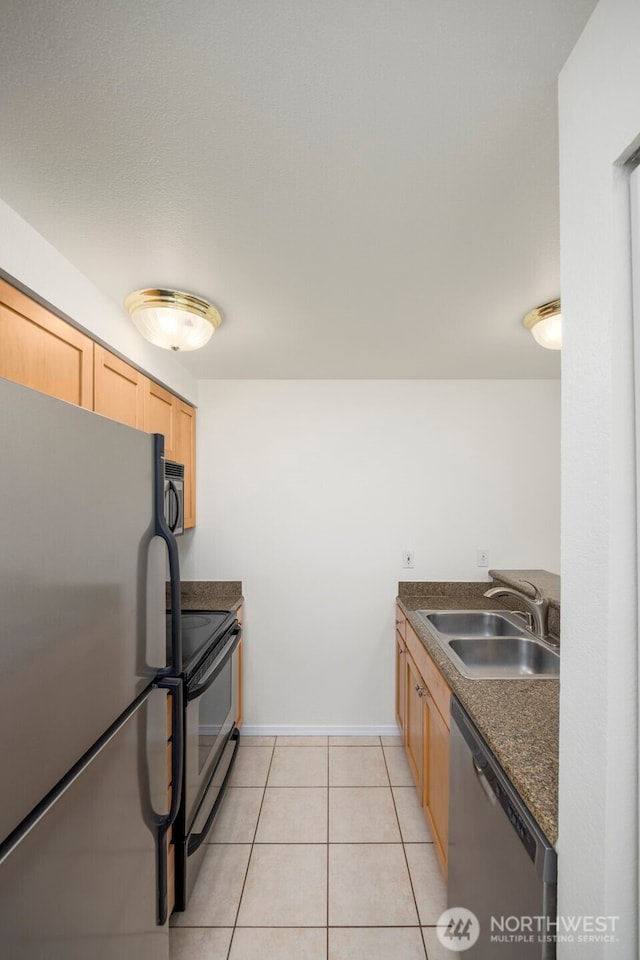 300 10th Ave Unit A310, Seattle, WA 98122 - kitchen with stainless steel appliances, dark countertops, light brown cabinetry, and light tile patterned floors