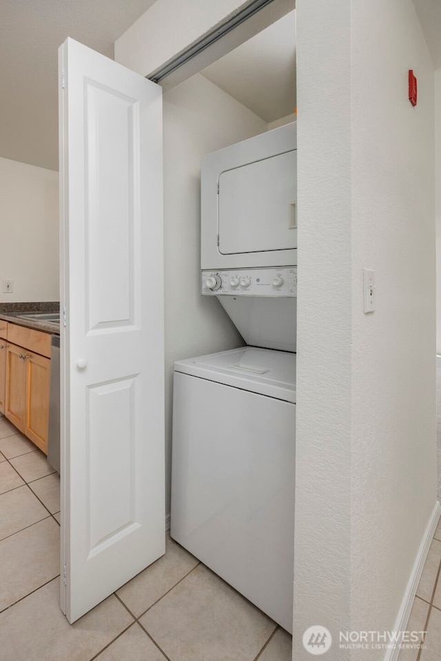 300 10th Ave Unit A310, Seattle, WA 98122 - washroom featuring stacked washing machine and dryer and light tile patterned flooring