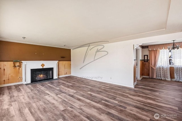 1727 E 64th St, Tacoma, WA 98404 - unfurnished living room with wood finished floors, a fireplace with flush hearth, and a chandelier