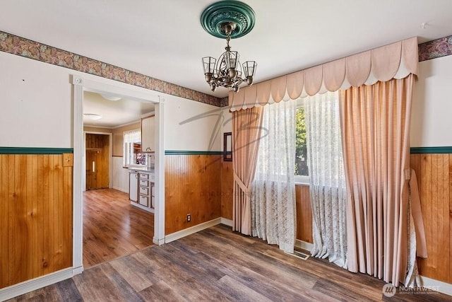 1727 E 64th St, Tacoma, WA 98404 - unfurnished dining area with a wainscoted wall, a chandelier, wood finished floors, and wood walls