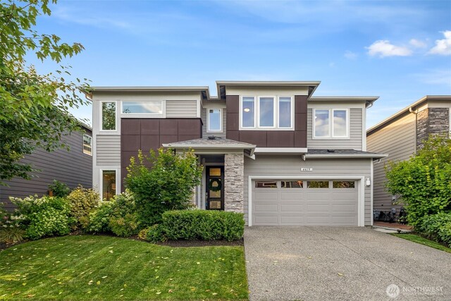4419 141st Pl SE, Snohomish, WA 98296 - view of front of house with a garage, concrete driveway, stone siding, and a front yard