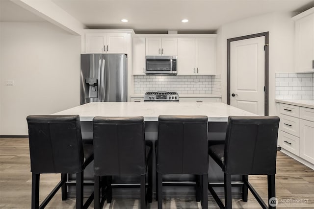 830 Mill Ave, Snohomish, WA 98290 - kitchen featuring stainless steel appliances, a kitchen bar, a kitchen island, white cabinets, and recessed lighting