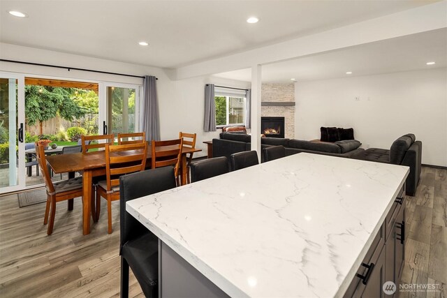 830 Mill Ave, Snohomish, WA 98290 - kitchen with light wood-style flooring, plenty of natural light, recessed lighting, a fireplace, and light stone countertops