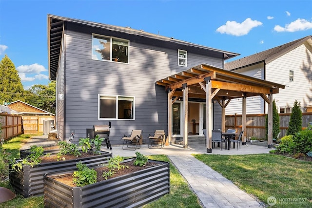 830 Mill Ave, Snohomish, WA 98290 - rear view of house featuring a vegetable garden, a fenced backyard, and a patio area