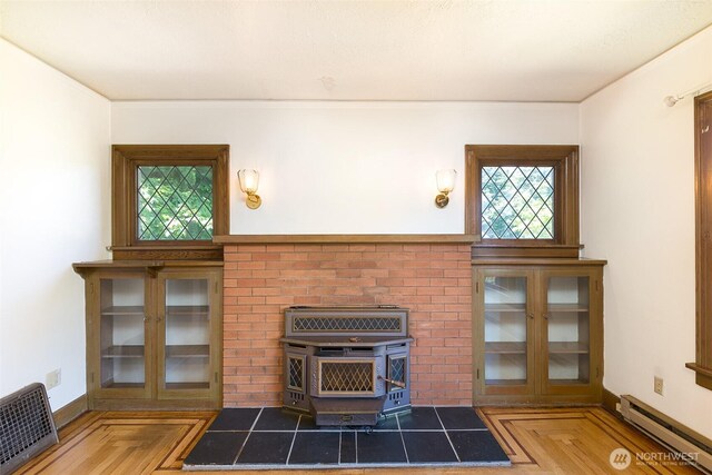 314 E 2nd St, Port Angeles, WA 98362 - unfurnished living room with a baseboard radiator, a wood stove, and crown molding